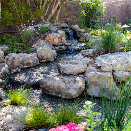 A custom water feature surrounded by pollinator friendly plants.